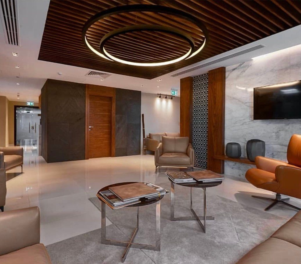 Reception lounge with a circular slatted-timber ceiling feature and walnut wall panels