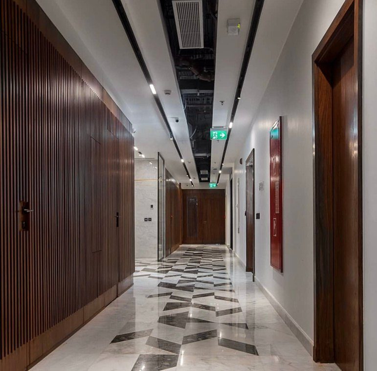 Corridor lined with full-height walnut panels and flush doors