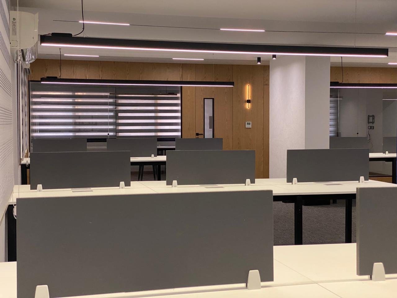 Open workspace with timber desks and window blinds